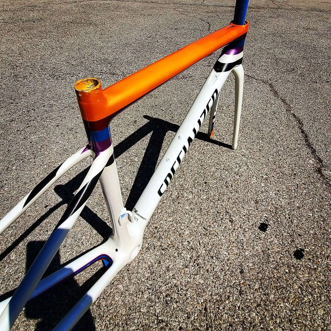 Custom bicycle paint design: white Specialized SL6 road frame with an orange top tube and blue purple panels